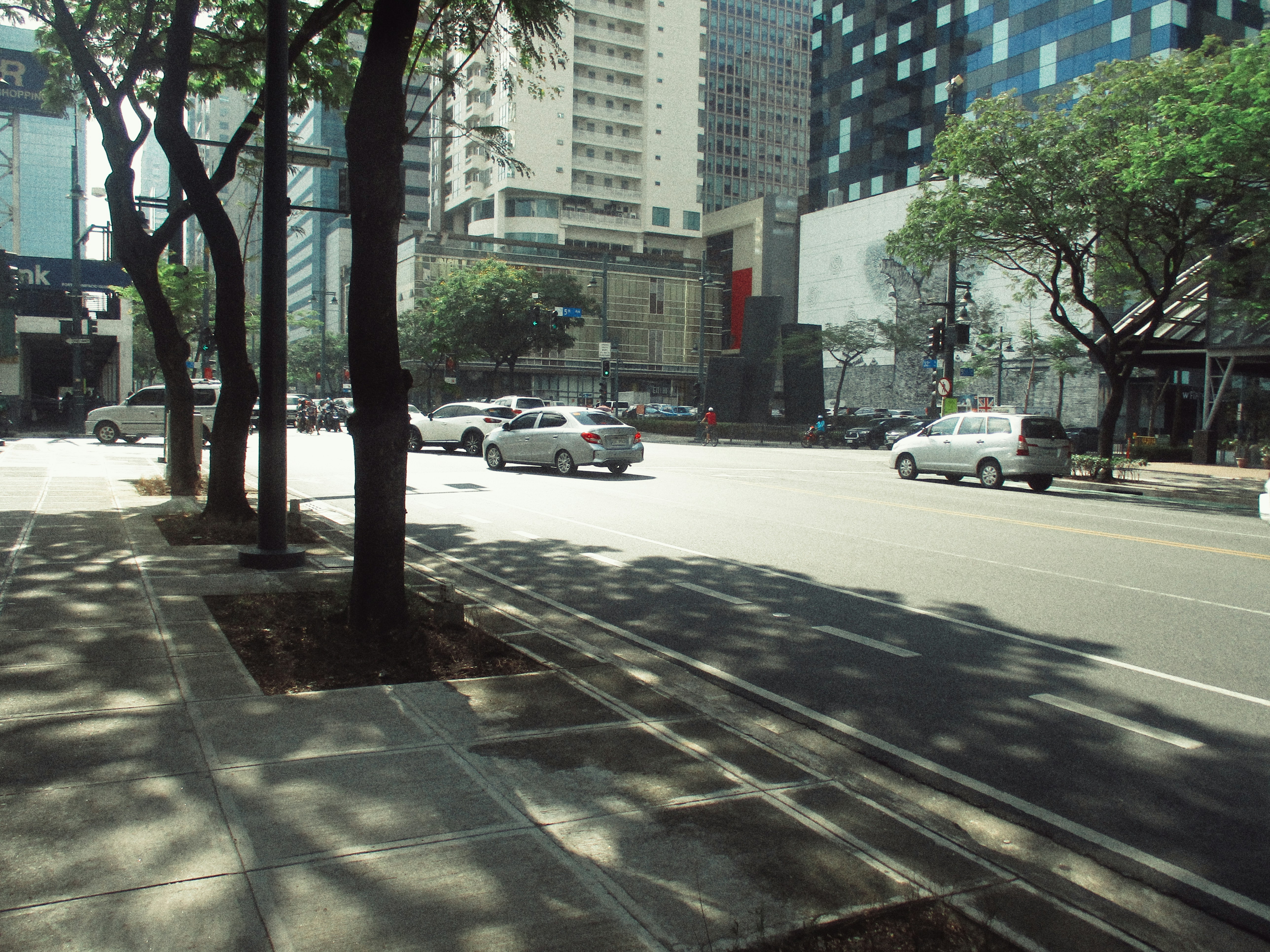 A city street filled with lots of traffic next to tall buildings