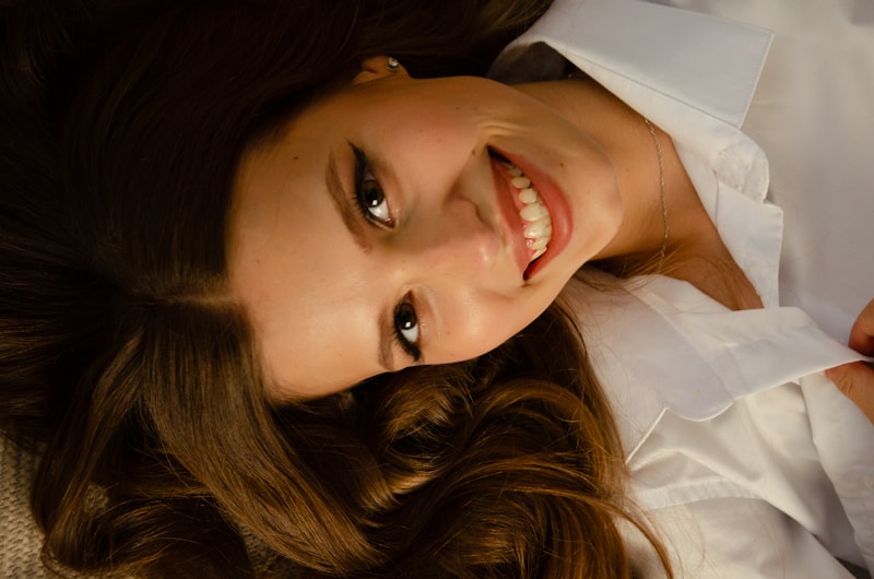 A woman laying on a couch smiling at the camera
