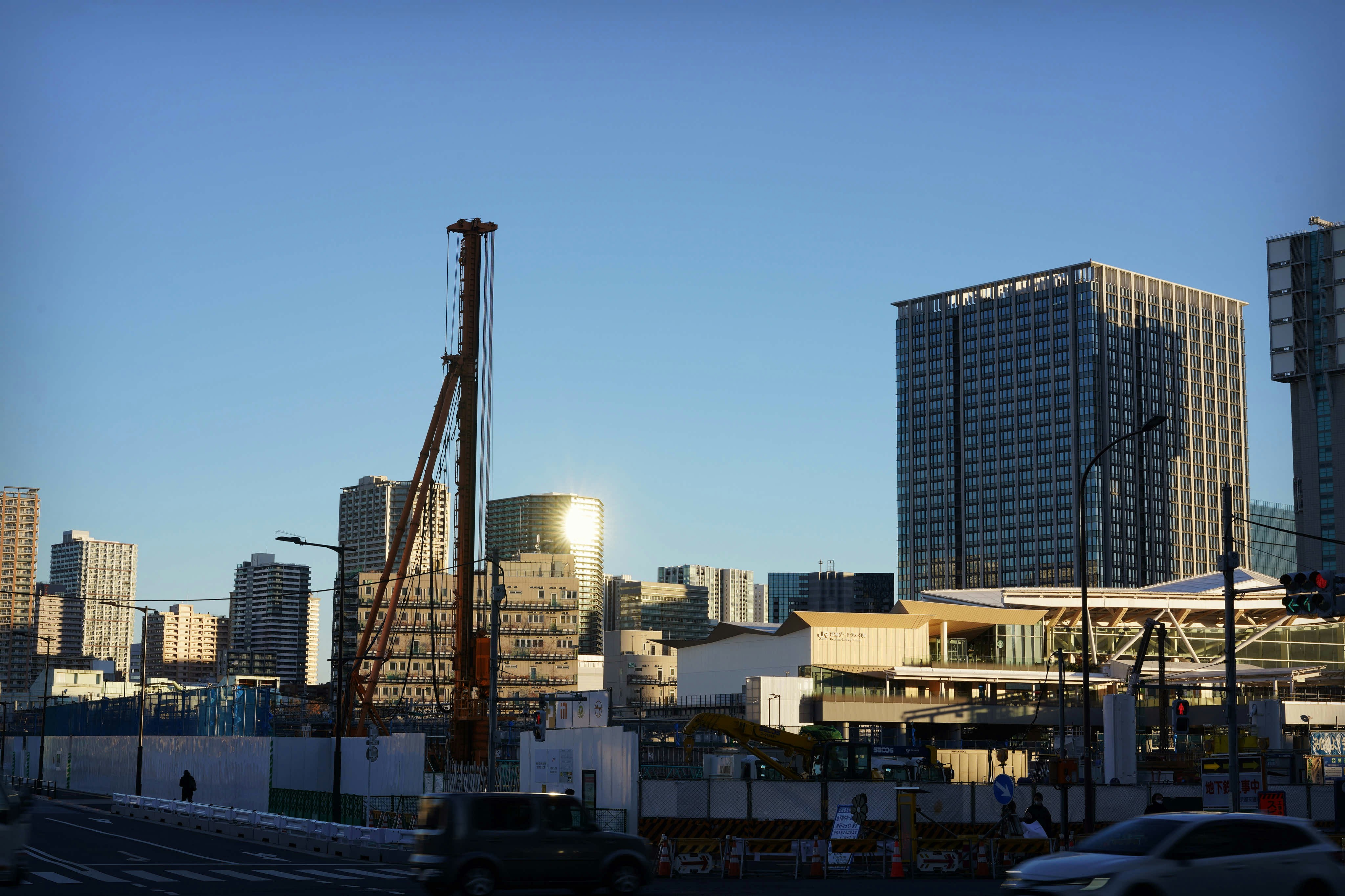 Construction site with cranes and modern building framework against a clear blue sky