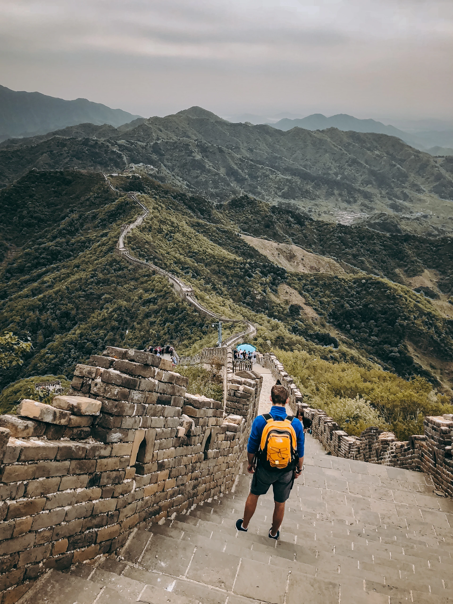 A man with a backpack walking up a mountain