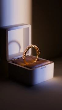 A gold ring sitting on top of a white box