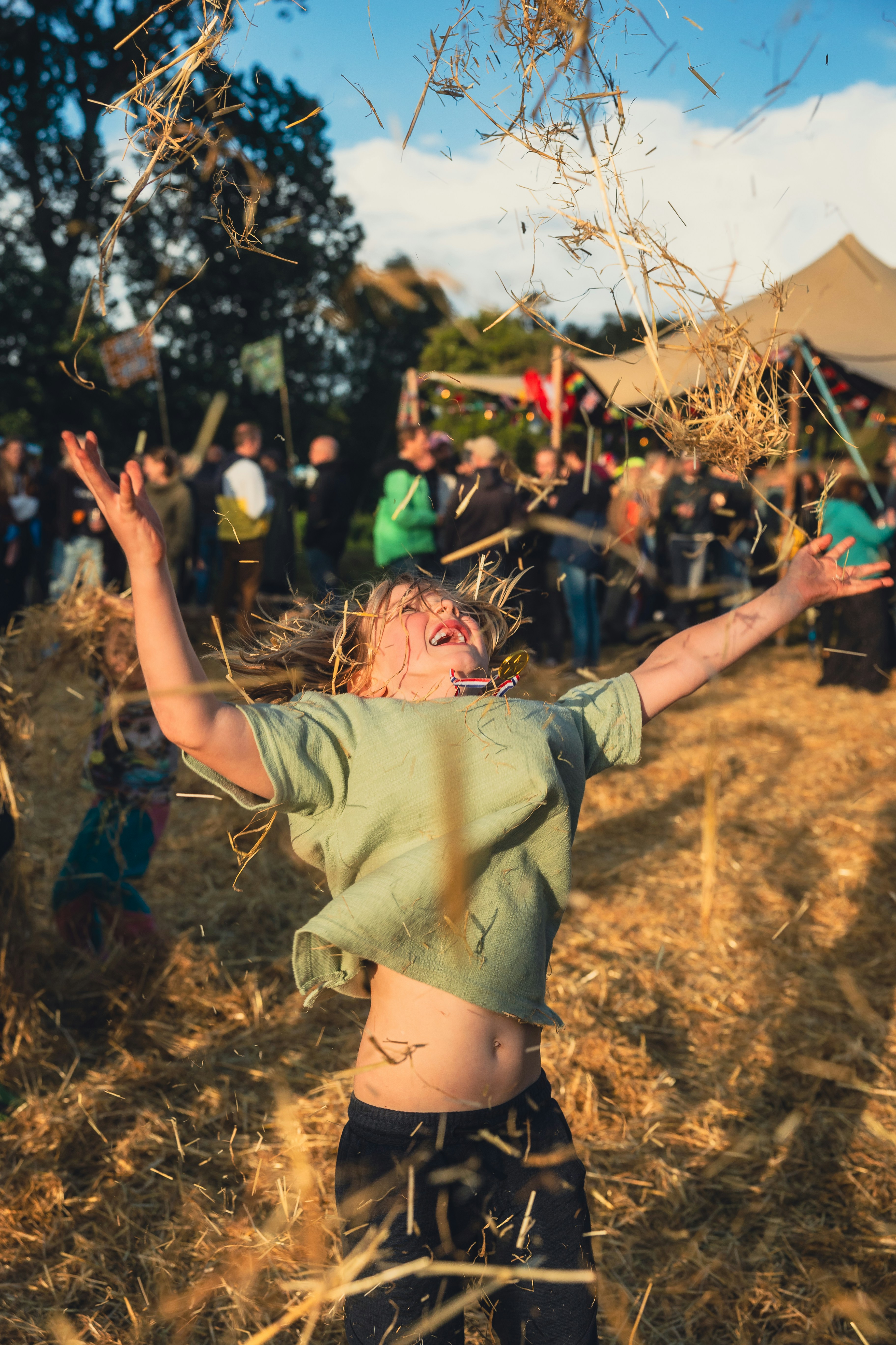 A young boy standing on top of a dry grass field