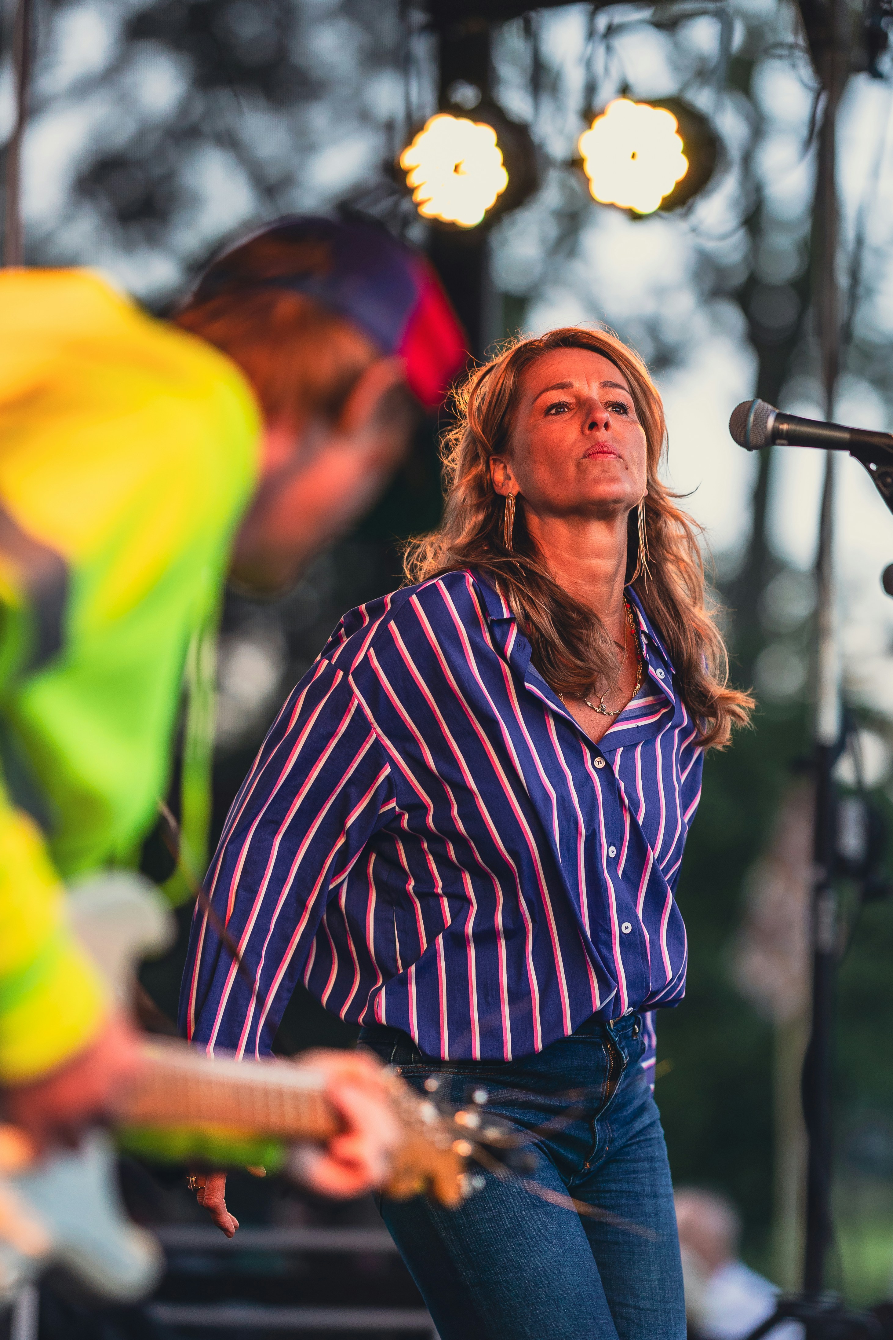 Eine Frau, die auf einer Bühne vor einem Mikrofon steht