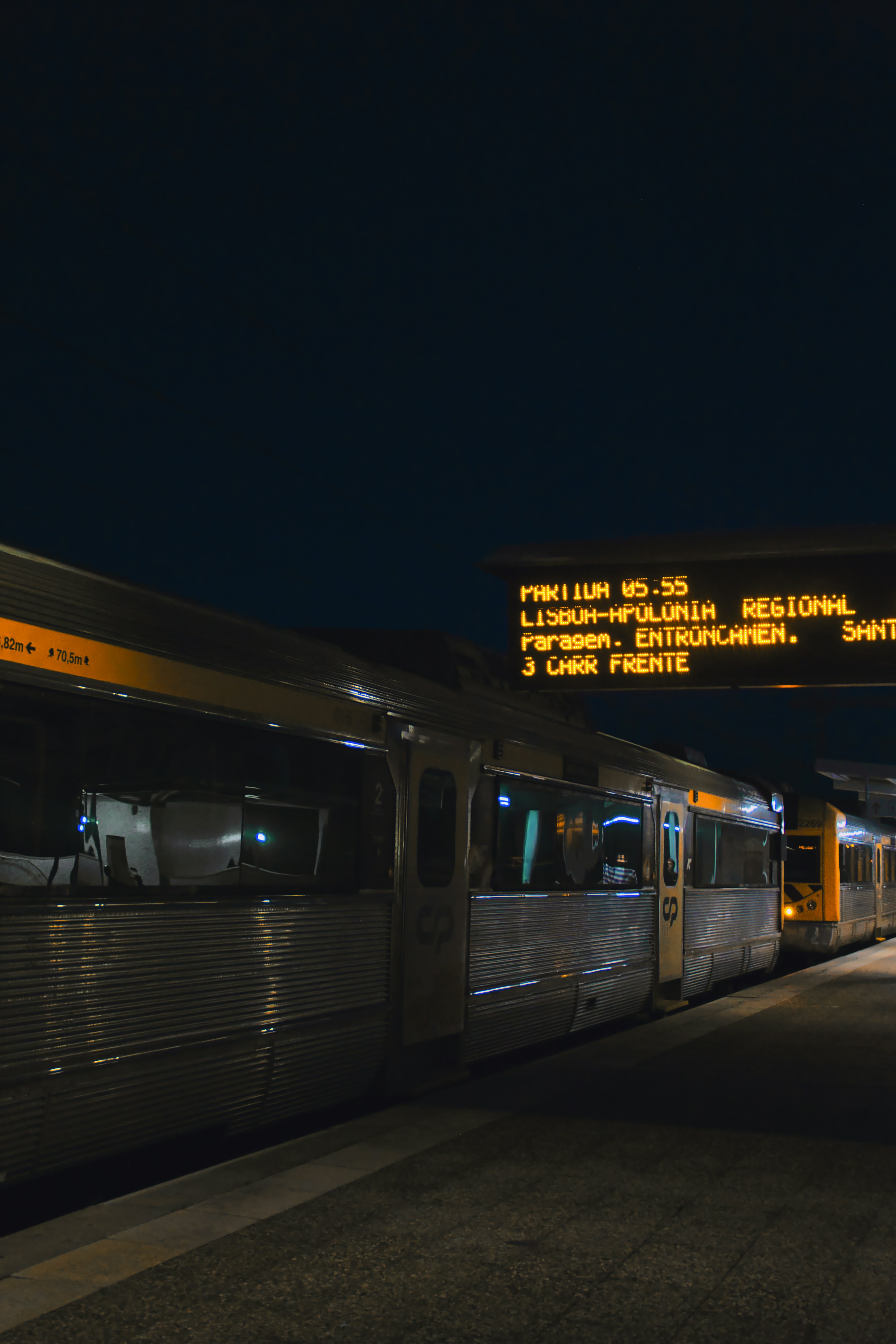 Un tren plateado viajando por las vías del tren por la noche