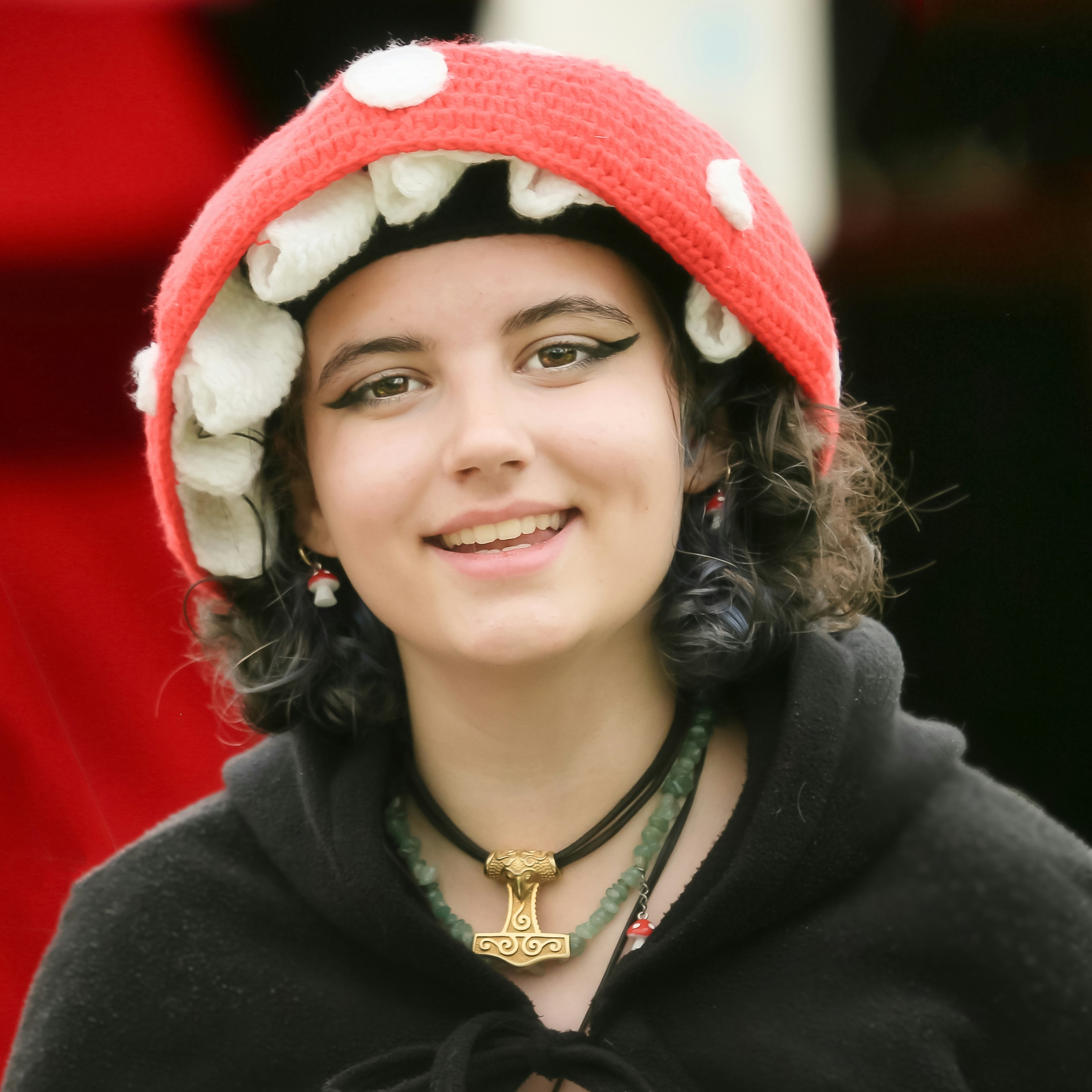 A woman wearing a red hat with white flowers on it