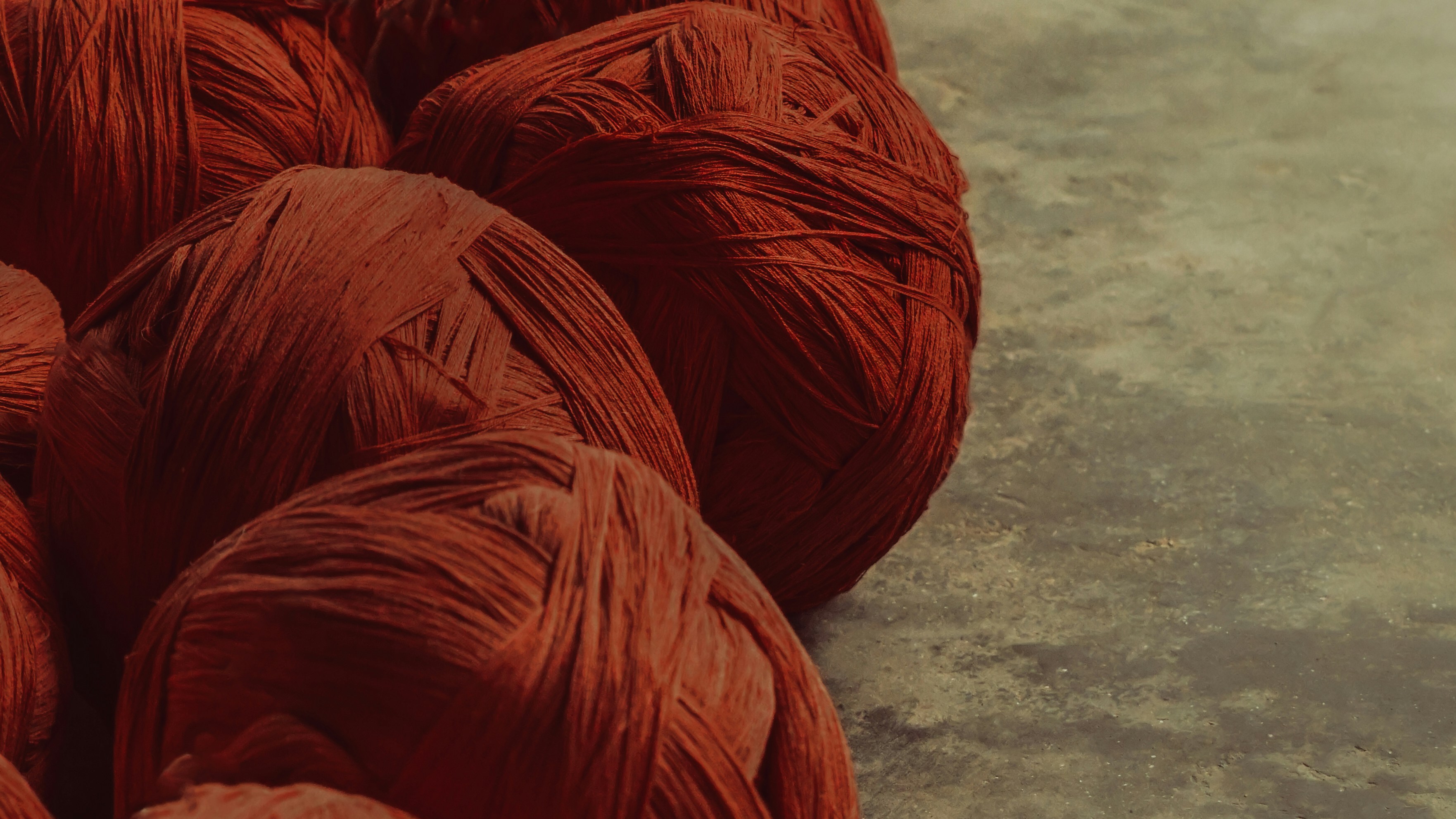 A group of red balls of yarn on the ground