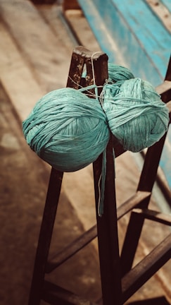 A ball of yarn sitting on top of a wooden chair