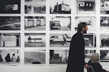 A man and a woman standing in front of a wall of pictures