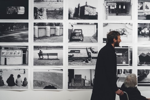 A man and a woman standing in front of a wall of pictures
