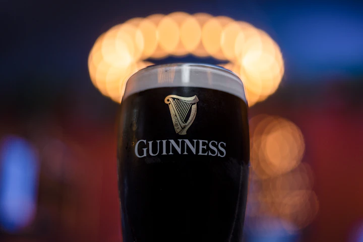 Pint of black stout with a creamy head, low-light close-up