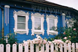 A blue house with a white picket fence