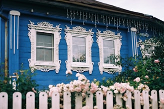 A blue house with a white picket fence