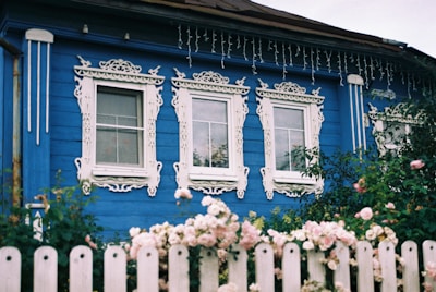 A blue house with a white picket fence