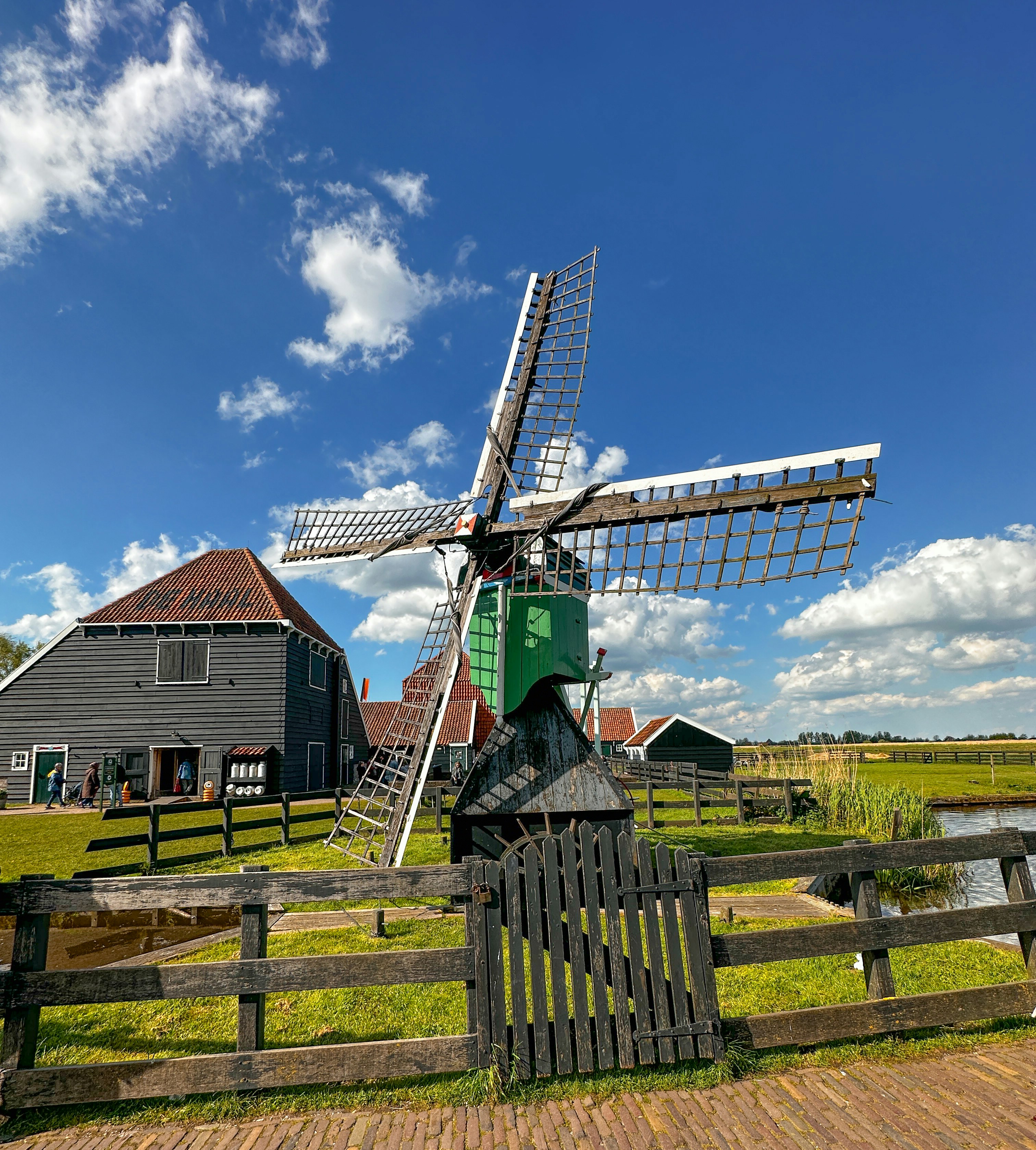 A windmill sitting on top of a lush green field