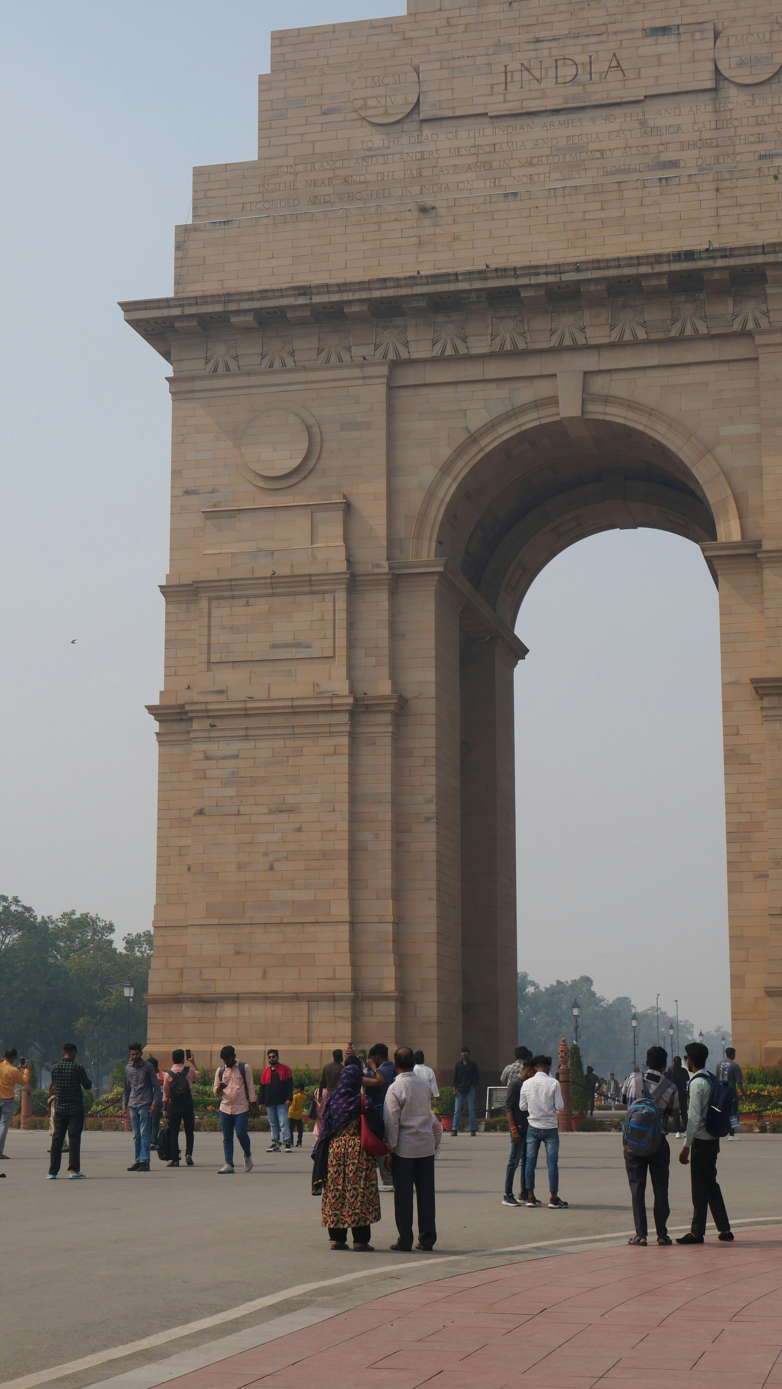 A group of people standing in front of a stone arch