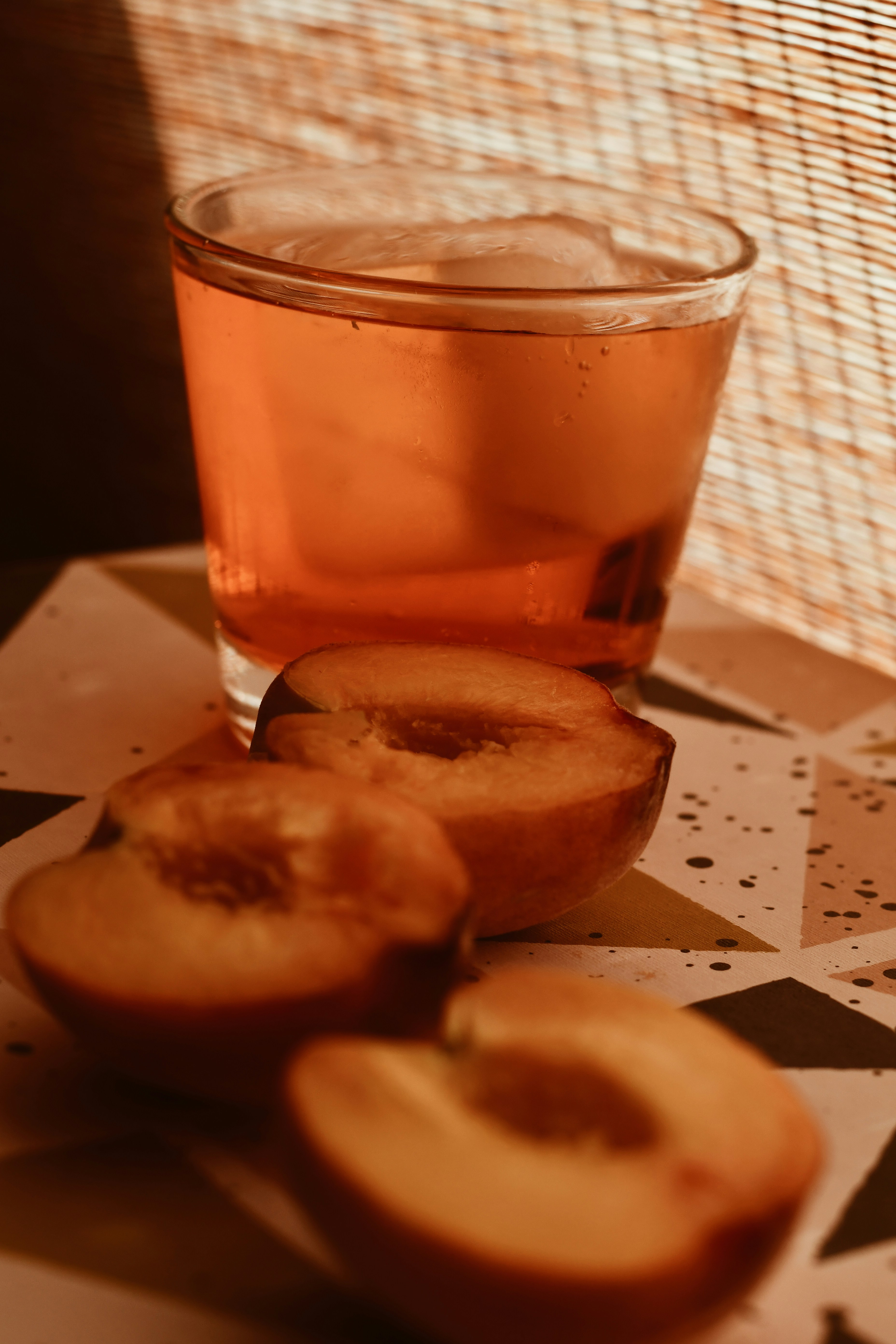 A glass of tea and sliced apples on a table
