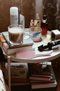 A white table topped with books and a cup of liquid