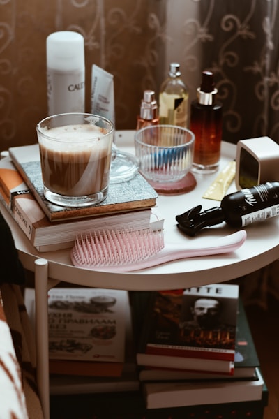 A white table topped with books and a cup of liquid