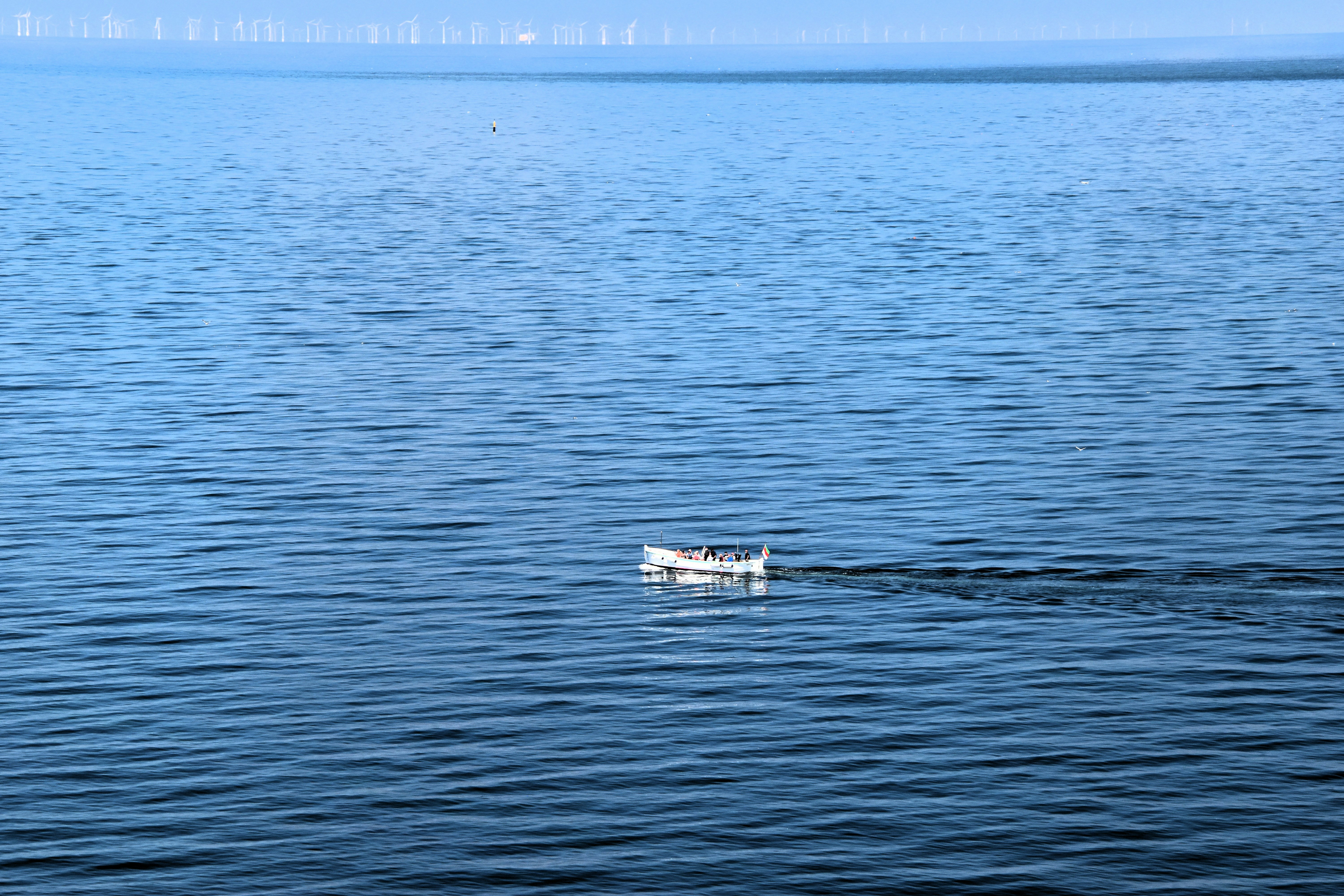 A small boat floating on top of a large body of water
