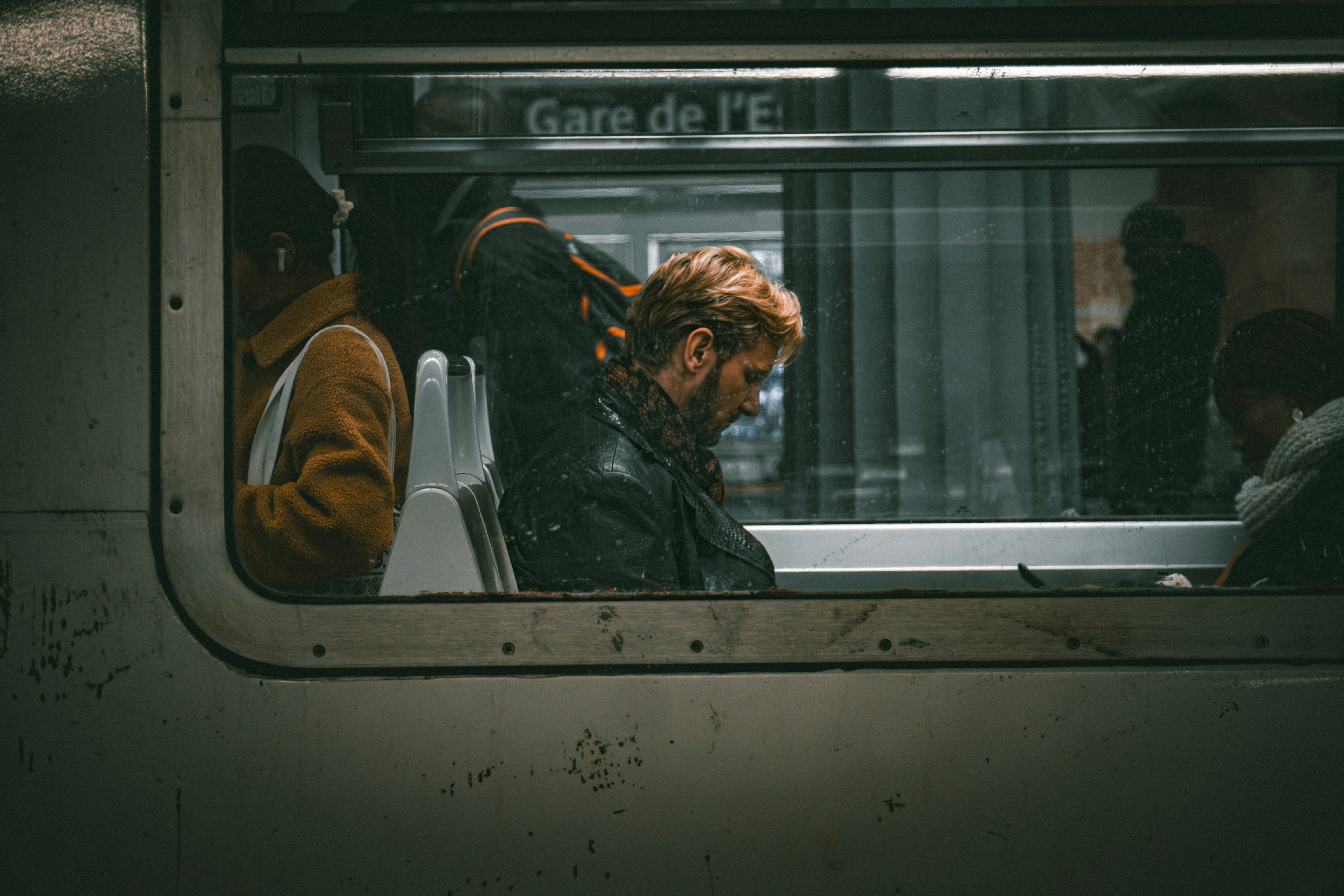 A man sitting on a train looking out the window