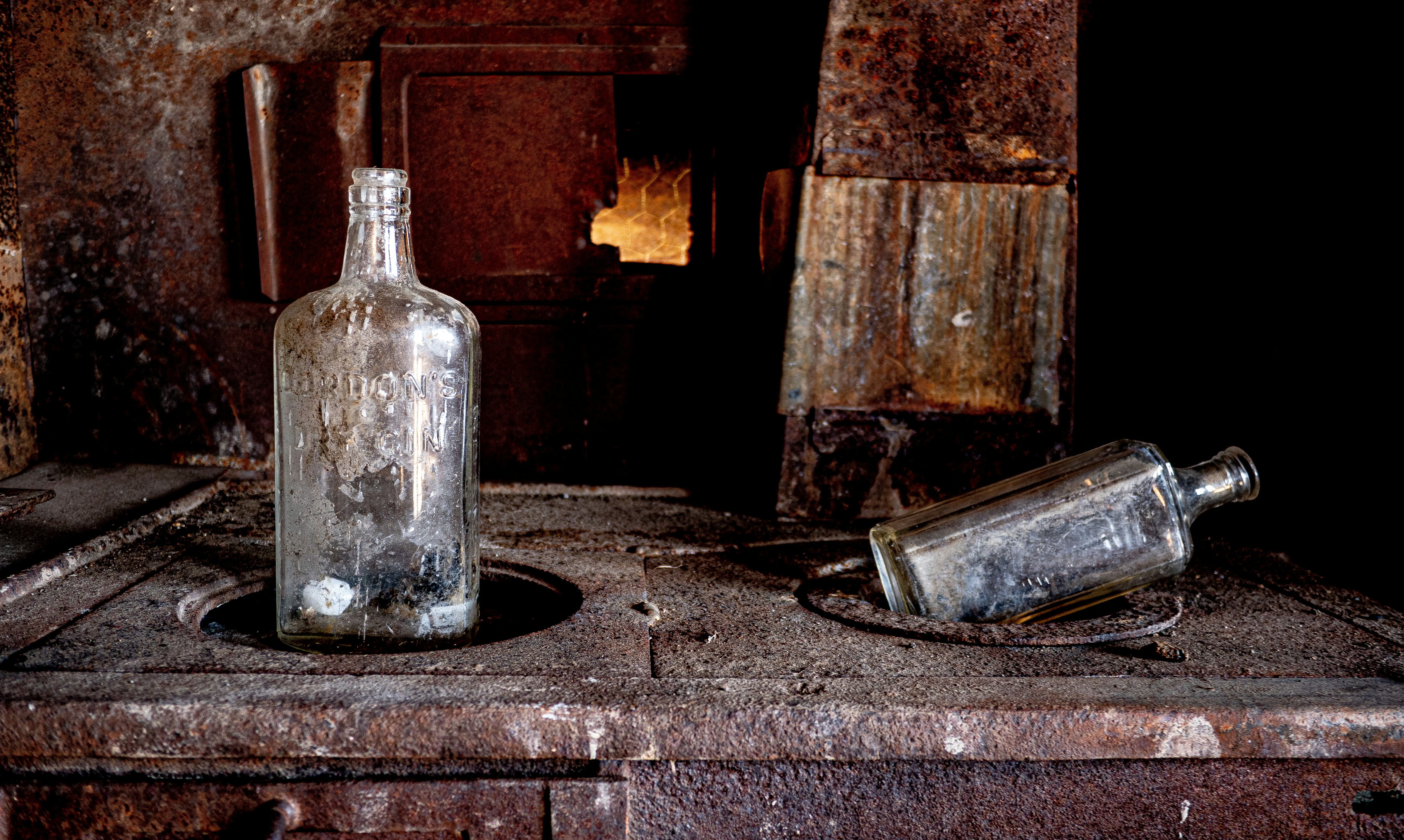 Two empty bottles sitting on top of a wooden table