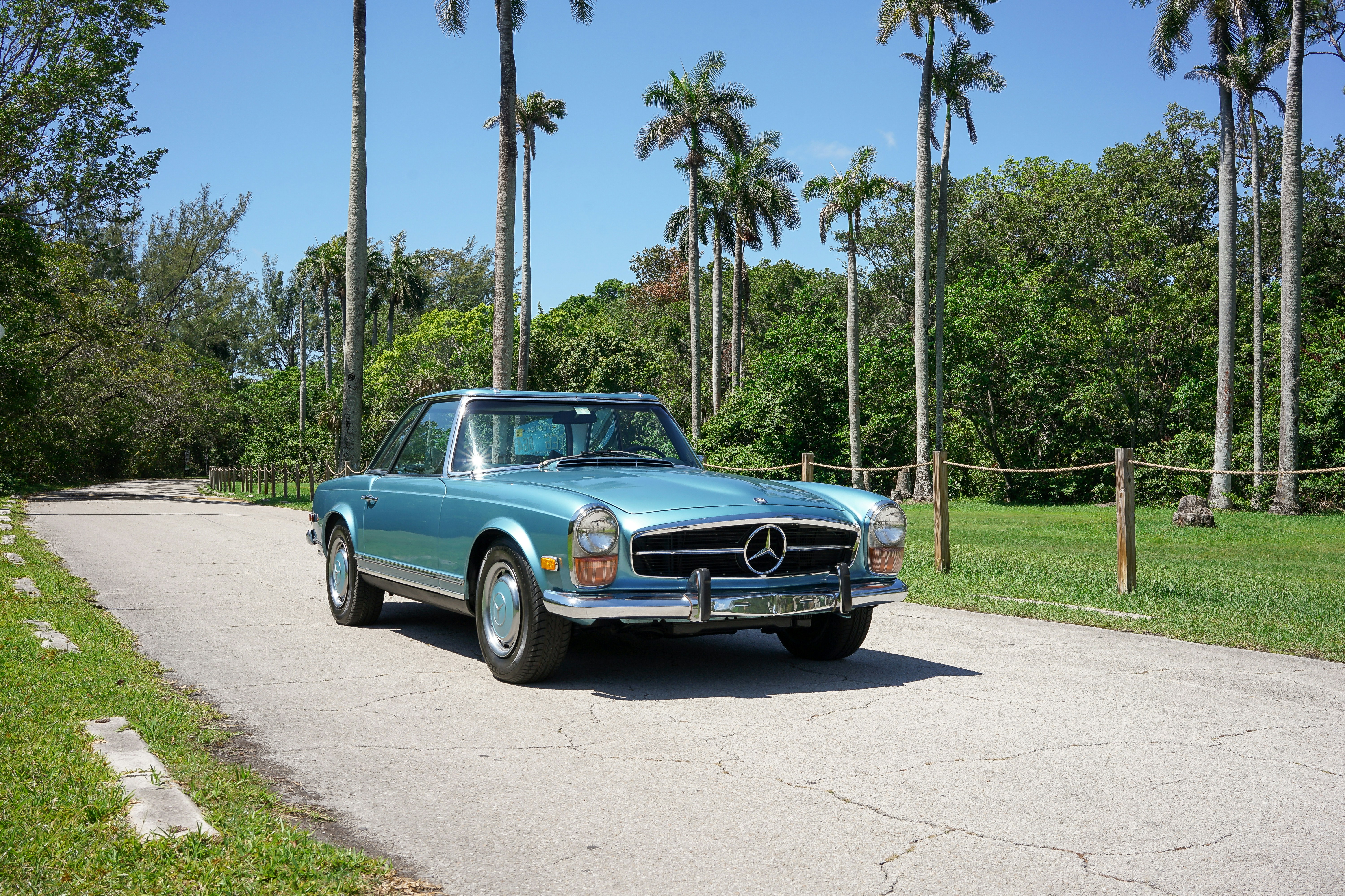 A blue car parked on the side of a road