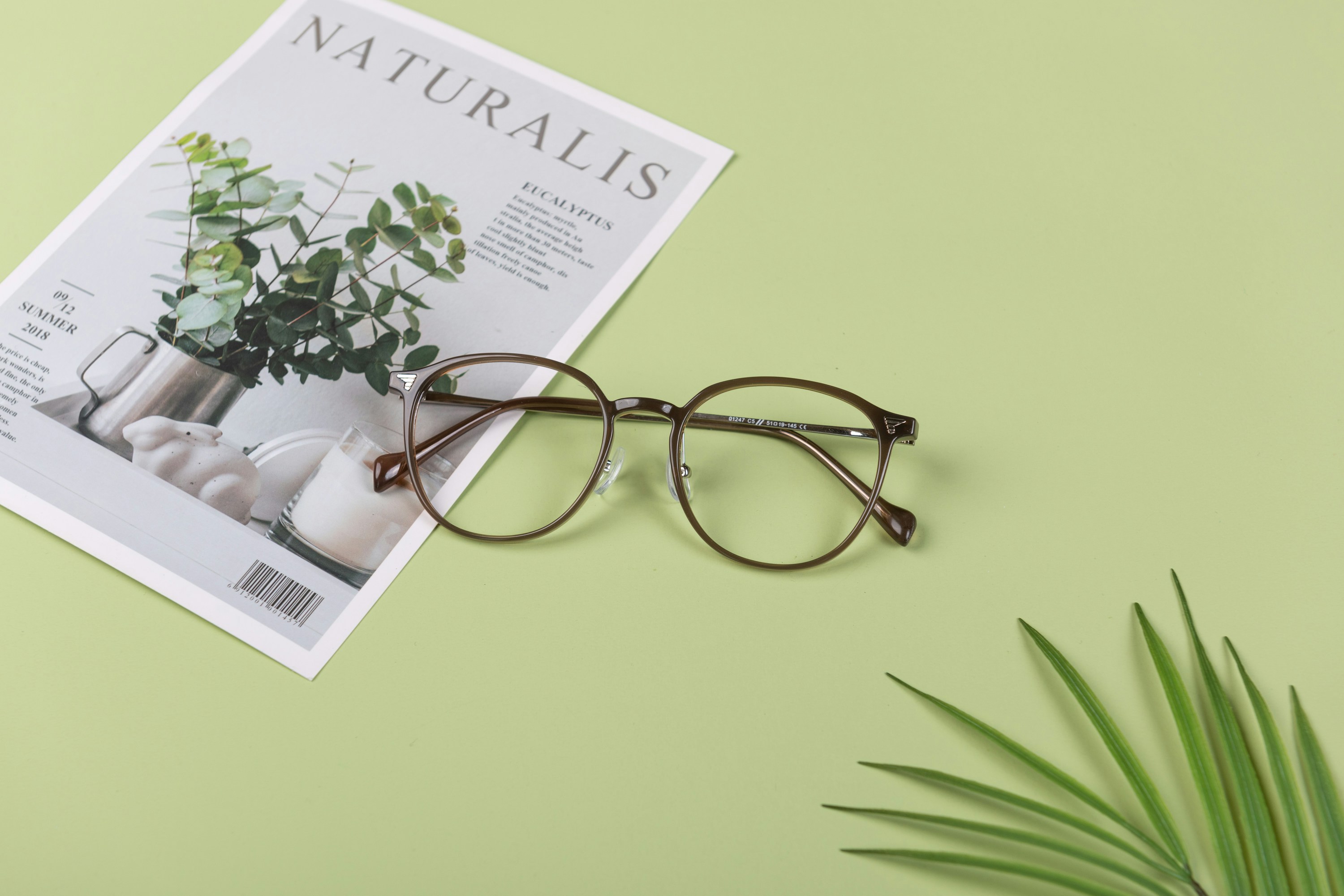 A pair of glasses sitting on top of a magazine