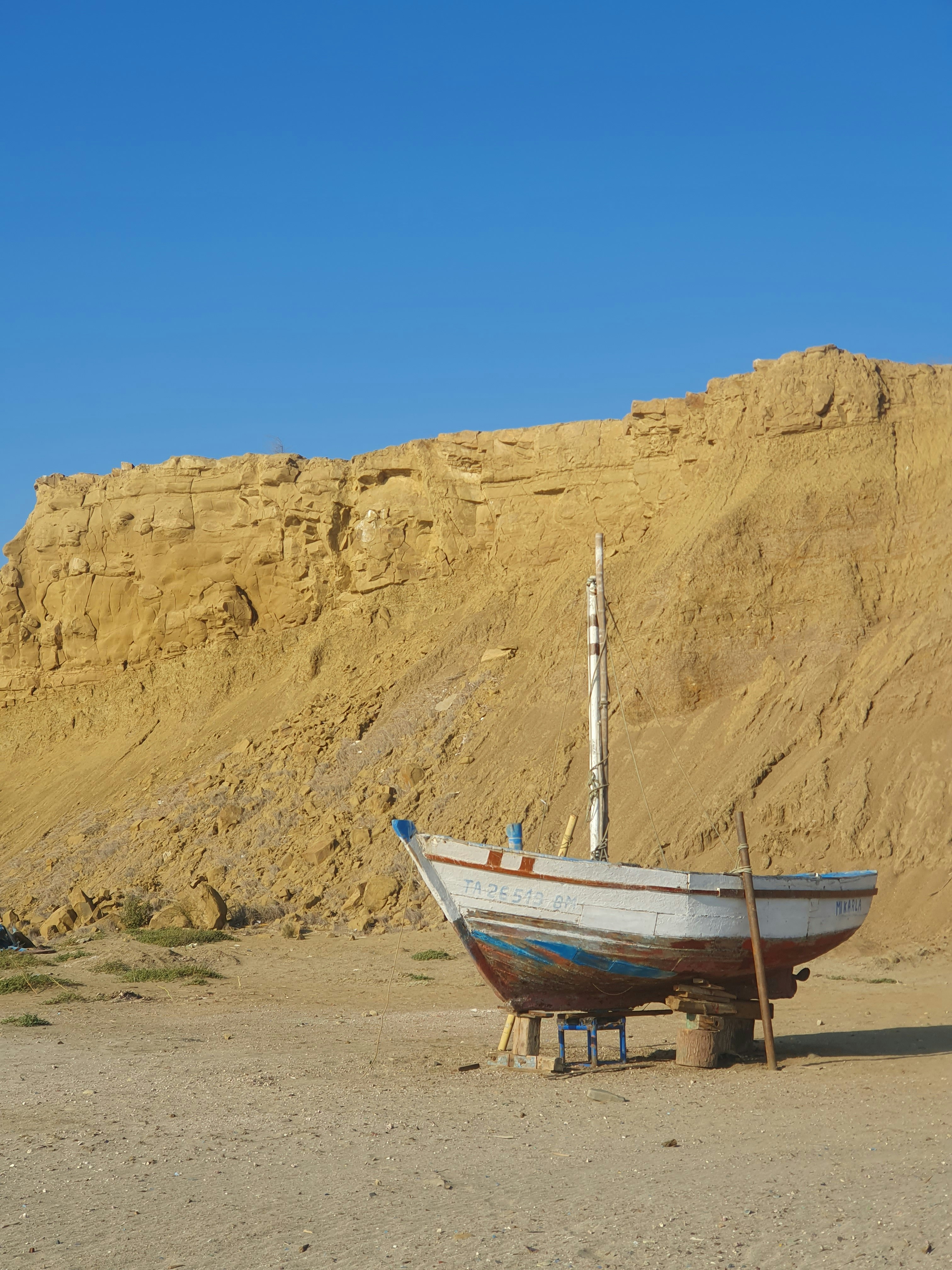A boat sitting on top of a sandy beach