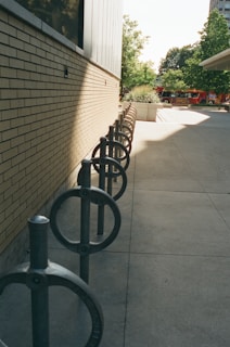 A row of black metal chairs sitting next to a building