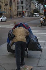 A person pushing a cart down a street