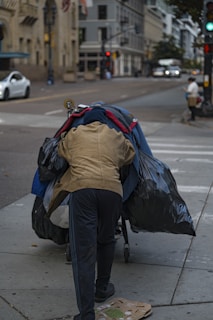 A person pushing a cart down a street