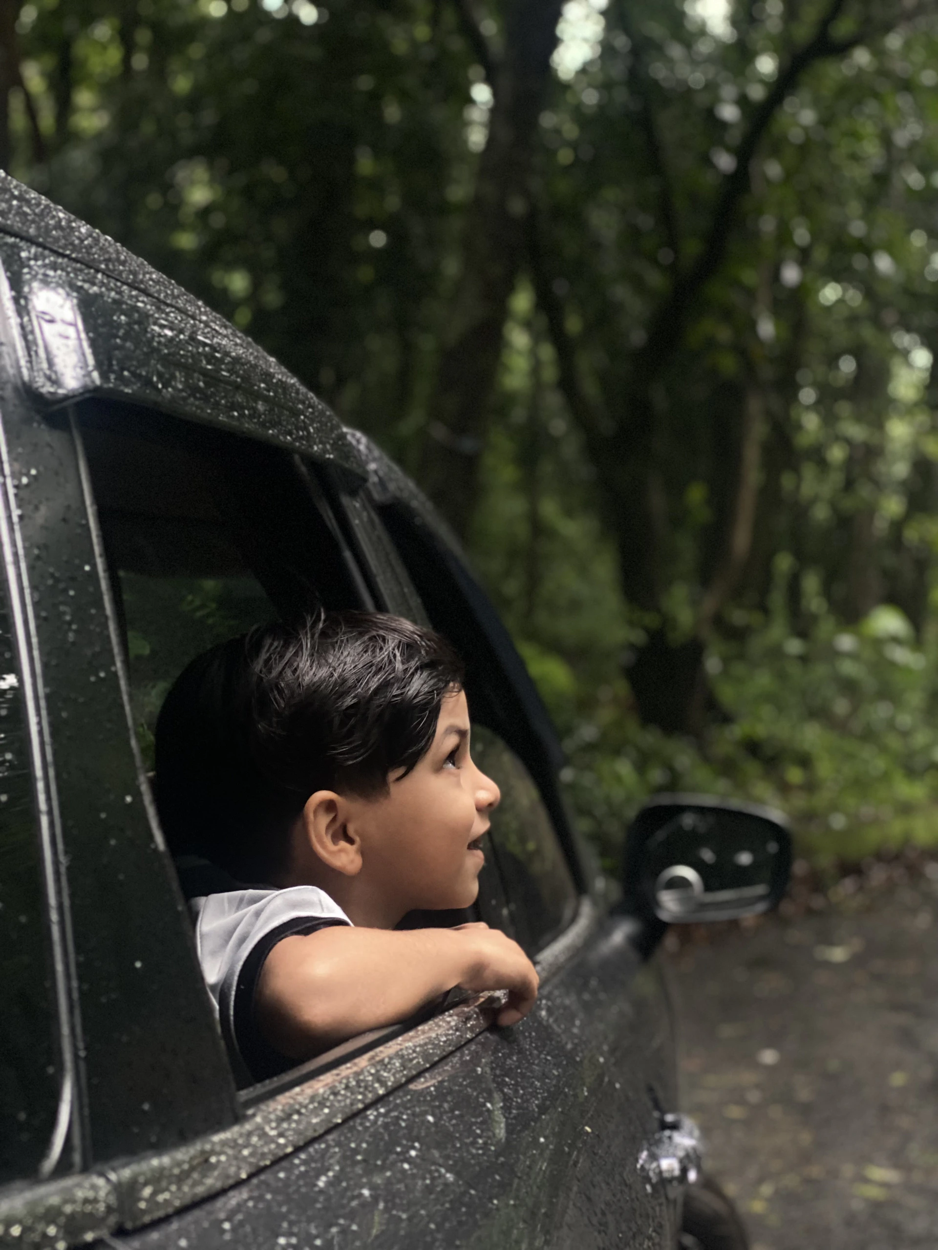 A young boy looking out the window of a car