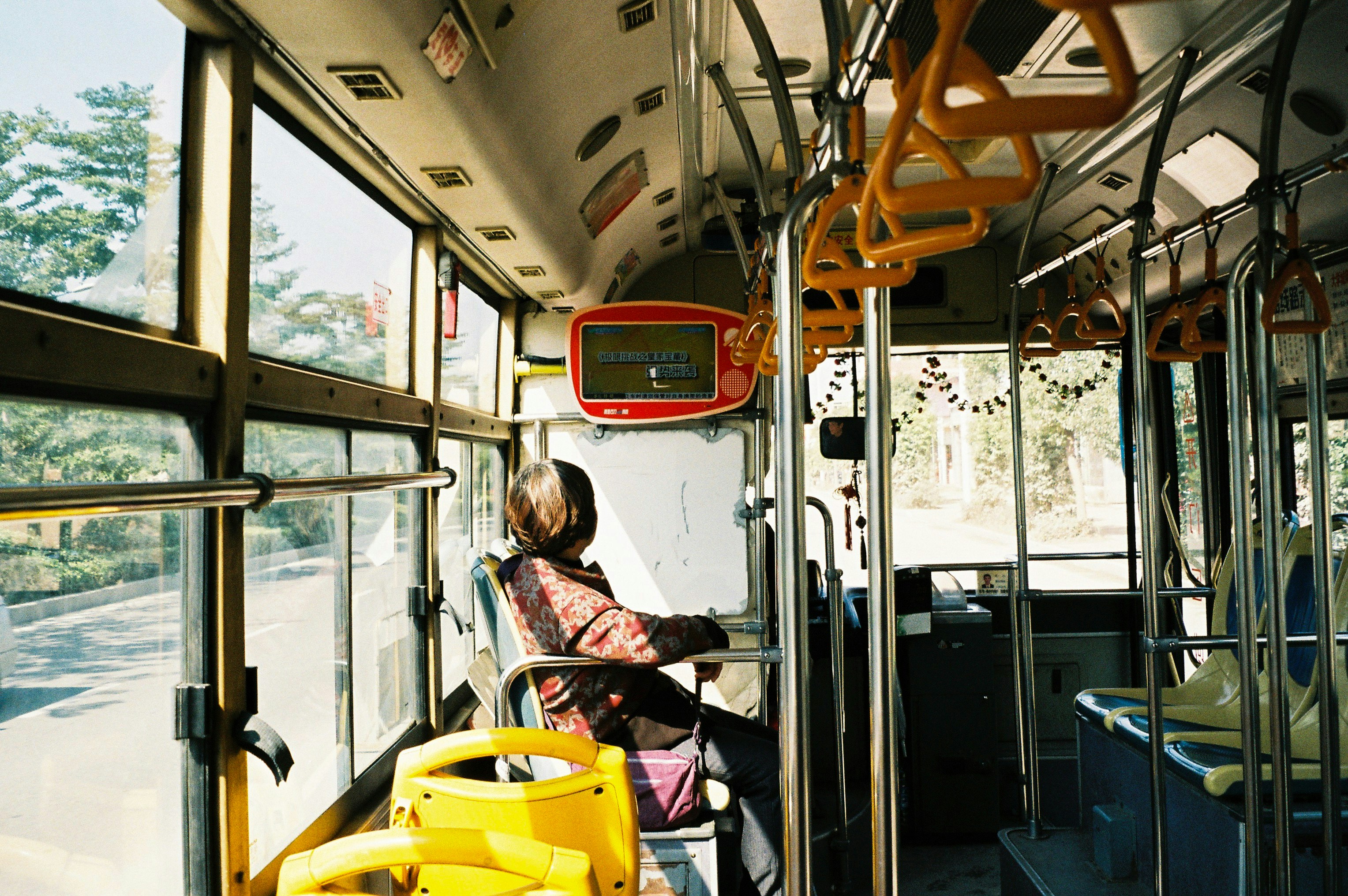 A woman sitting on a bus looking out the window