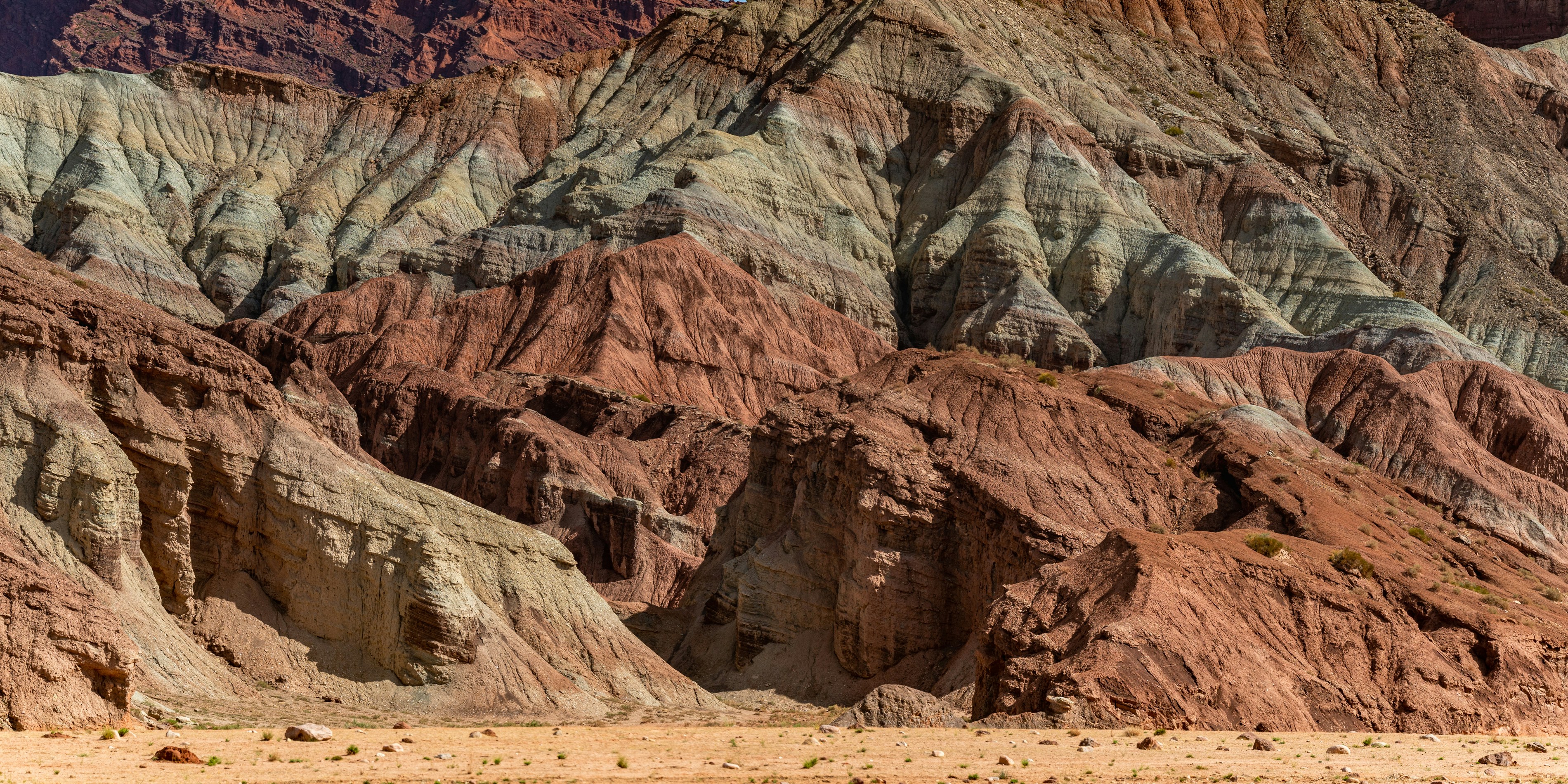 A group of people riding horses through a desert