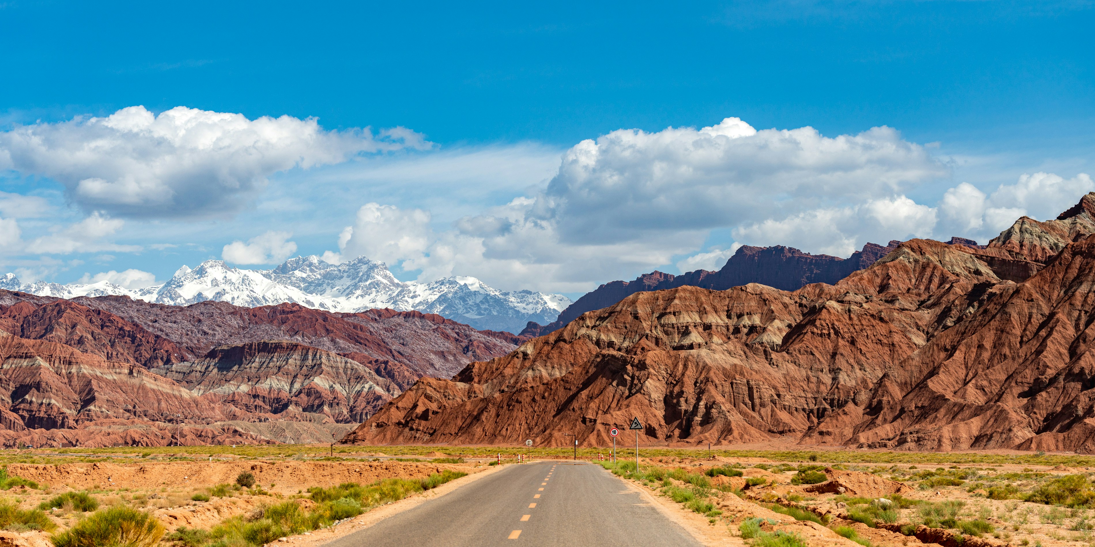 A road in the middle of a desert with mountains in the background