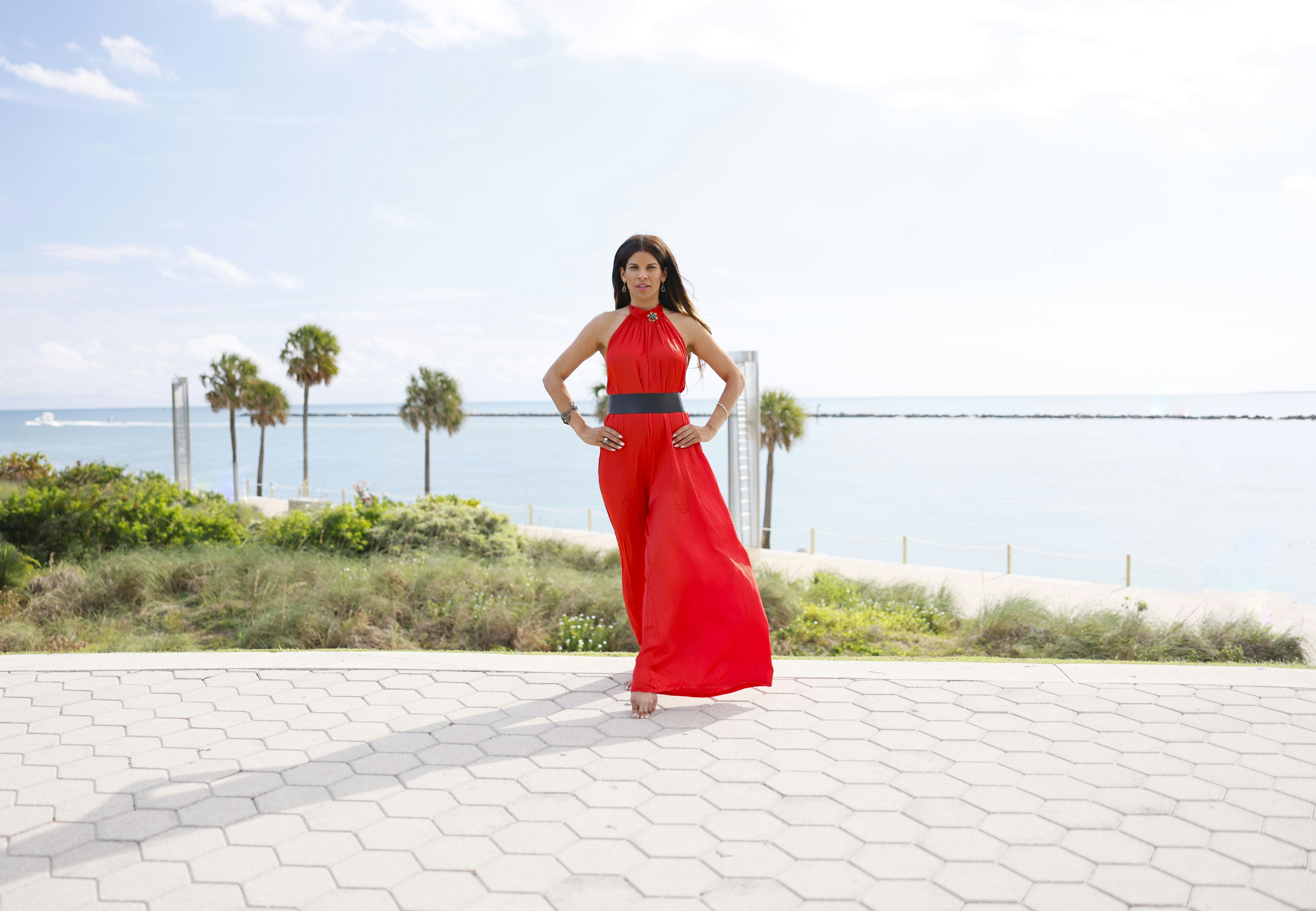 A woman in a red dress standing on a sidewalk