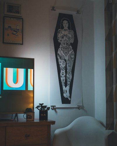 A framed abstract art print hanging above a living room sofa