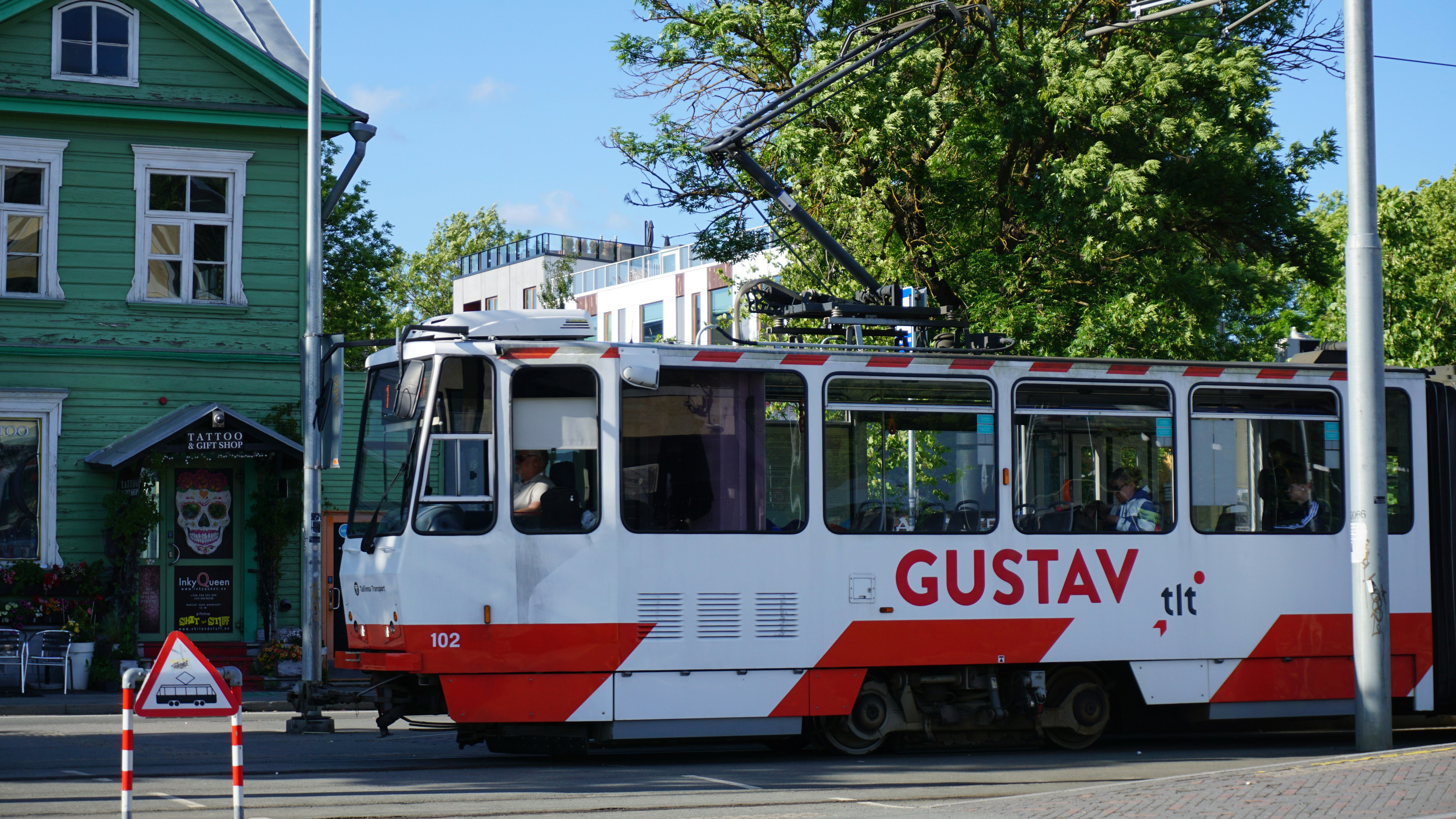 A red and white bus driving down a street