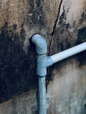 A blue pipe sticking out of the side of a building