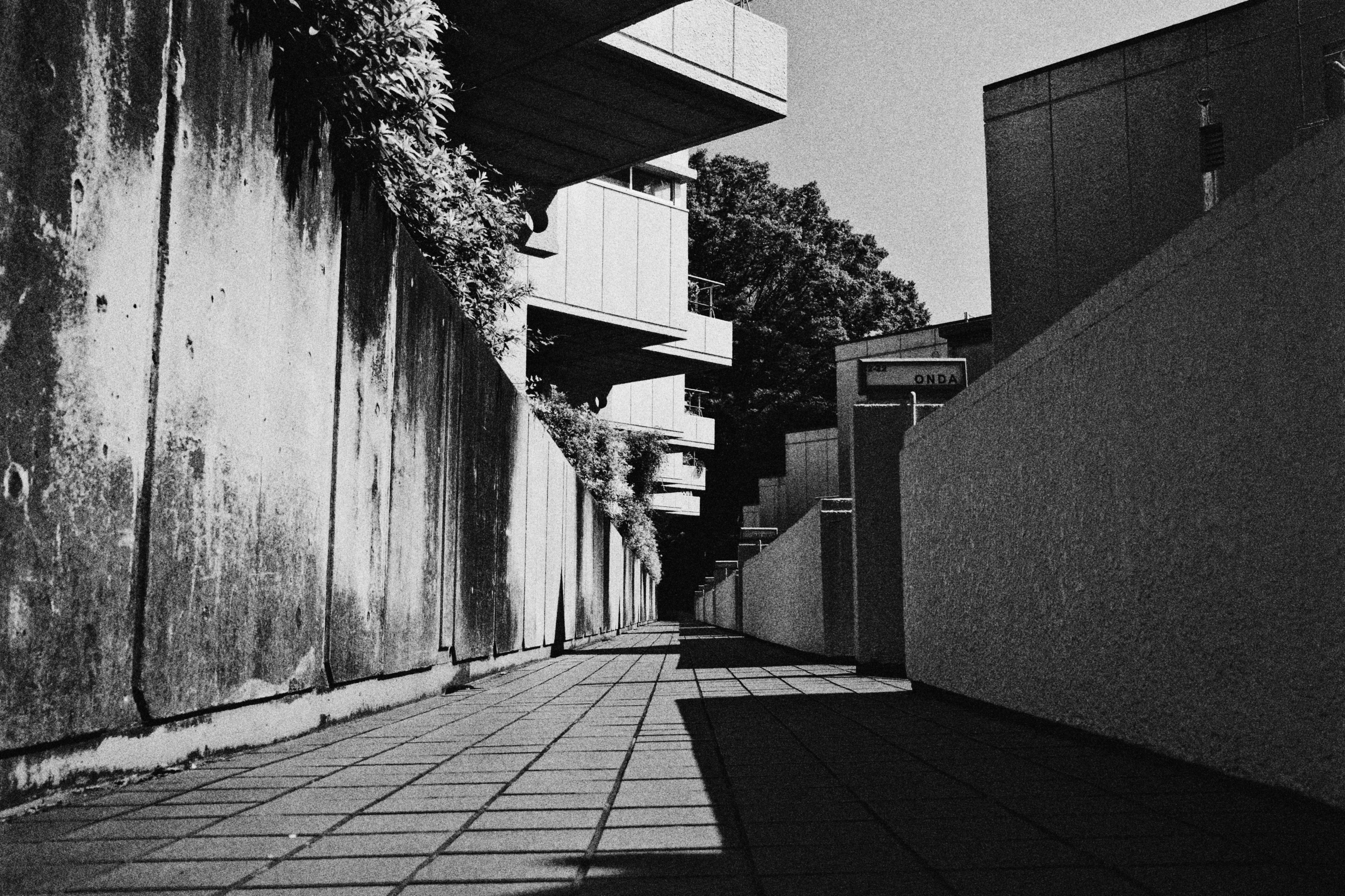 A black and white photo of a narrow street