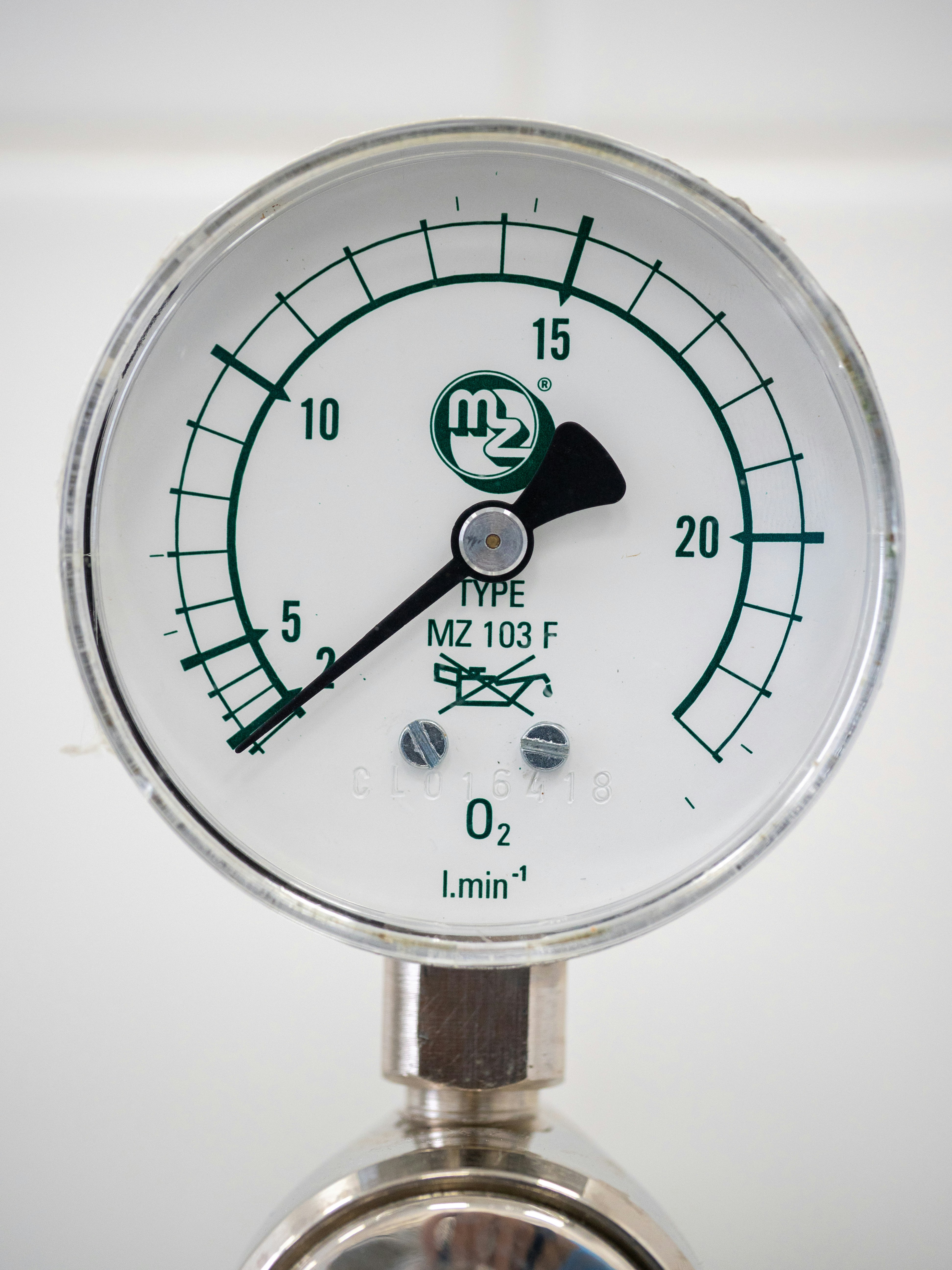A close up of a pressure gauge on a white background