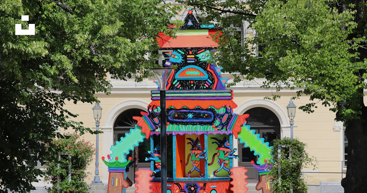 Clock Tower Color Designs A colorful clock tower in front of a building photo – Free Robot Image ...