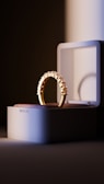 A gold ring sitting on top of a white box