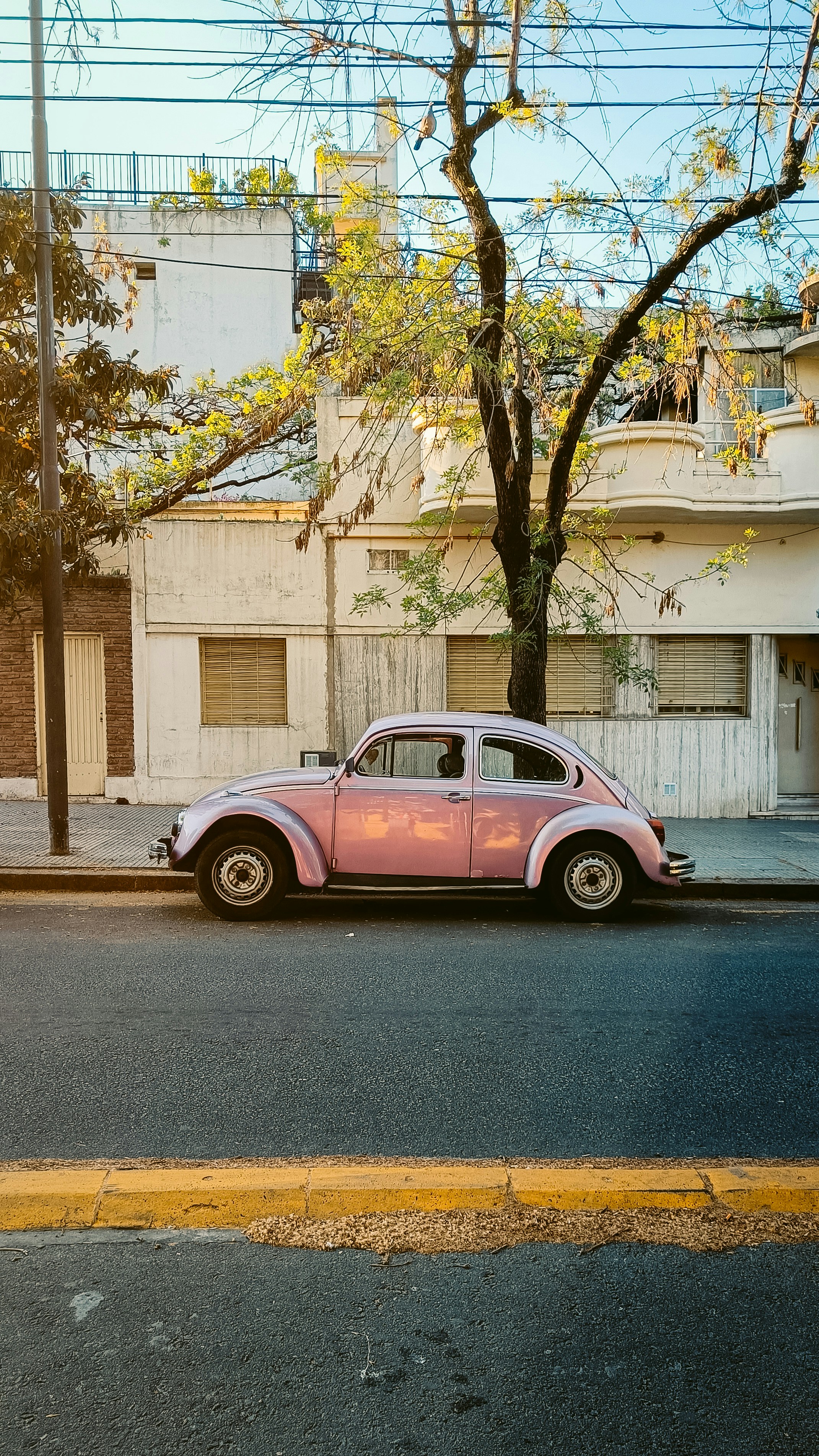 A pink car parked on the side of the road