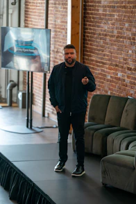 A man standing on a stage in front of a brick wall