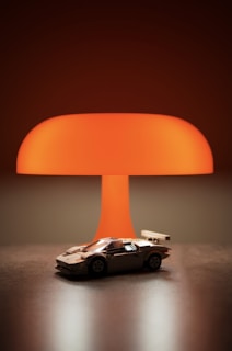 A toy car under a large orange lamp