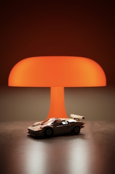 A toy car under a large orange lamp