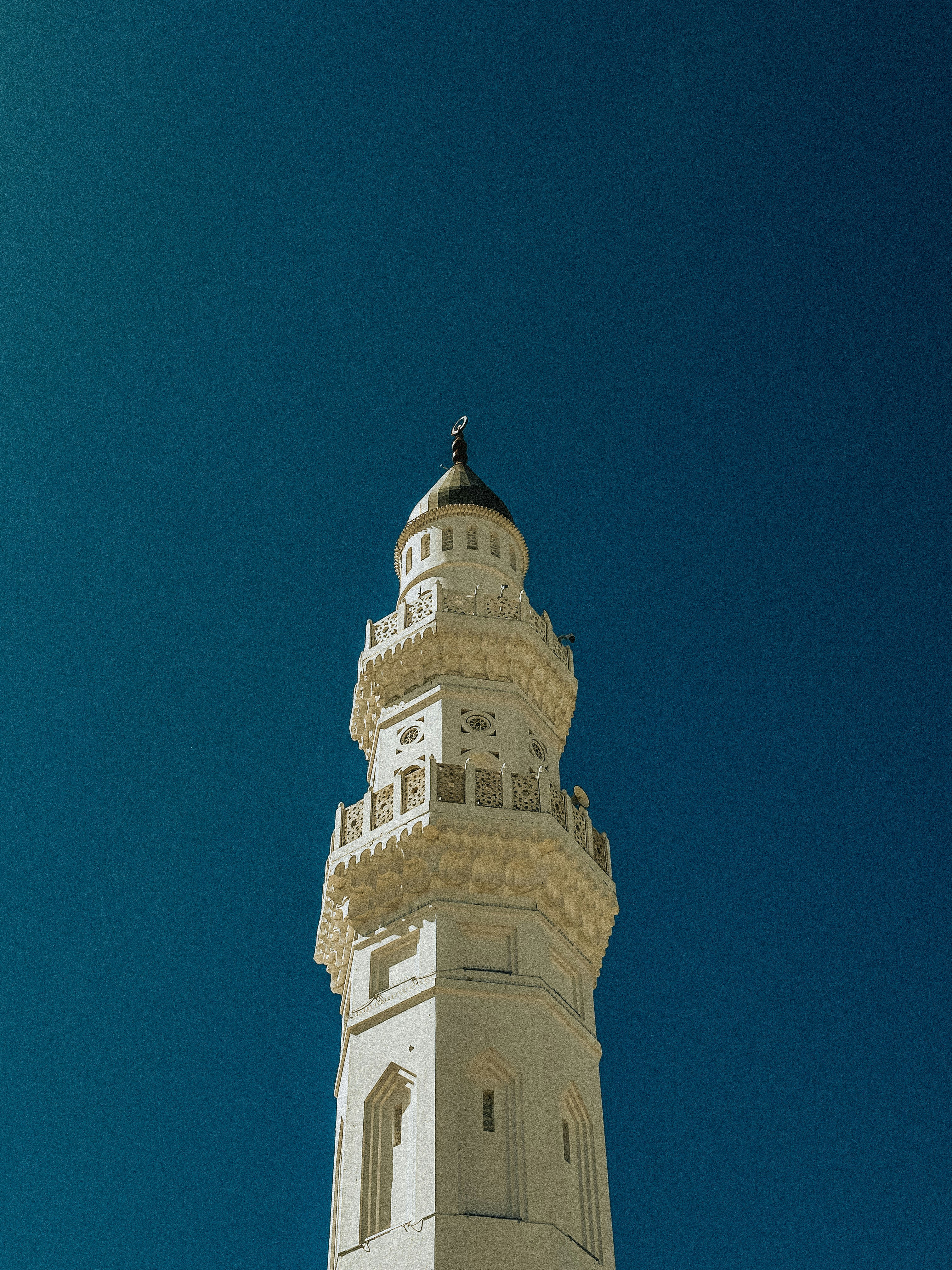 A tall white tower with a clock on it's side