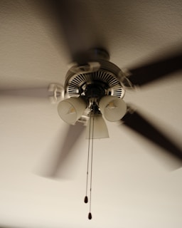 A ceiling fan that is hanging from a ceiling