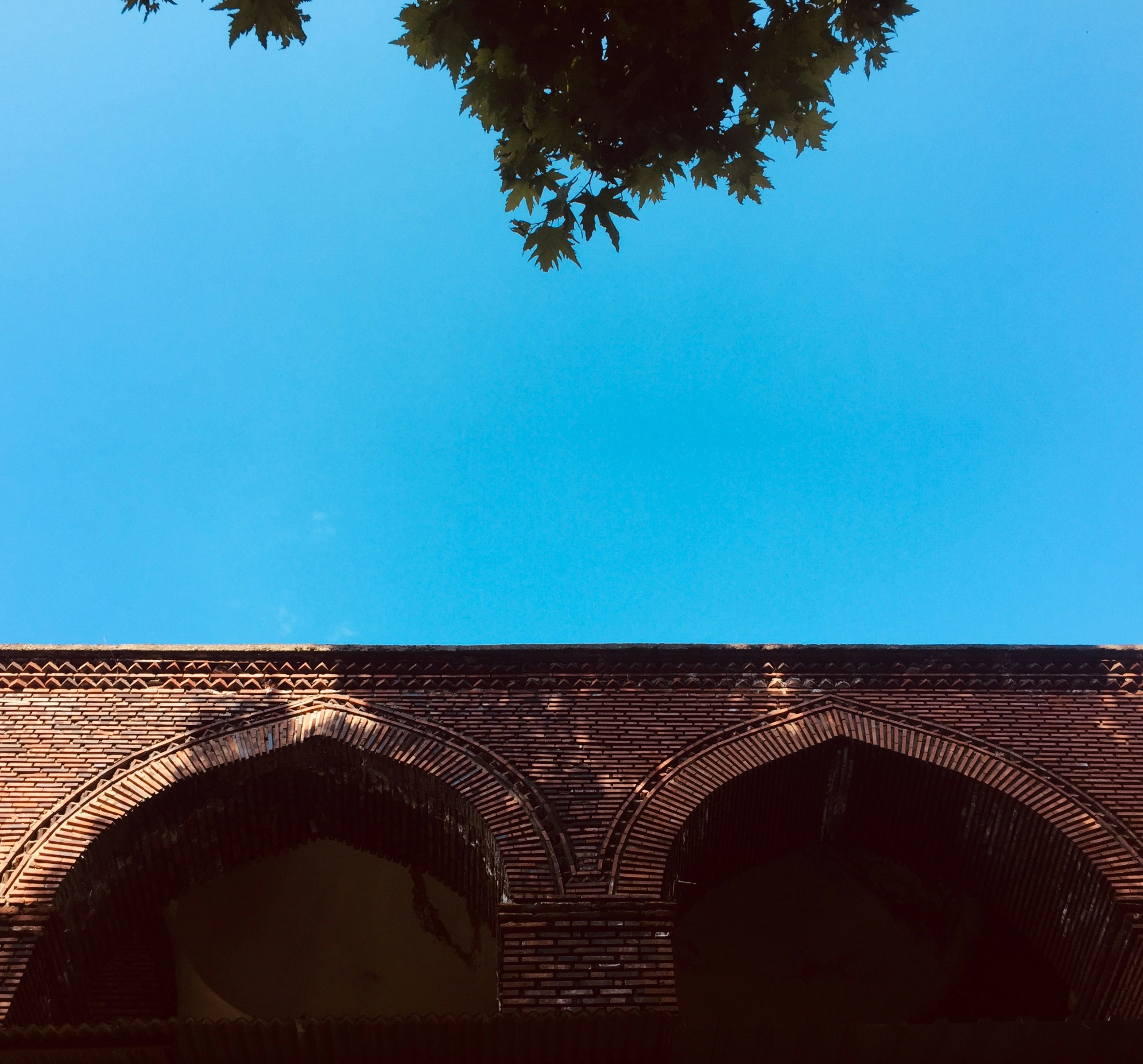 A building with arches and a blue sky in the background